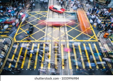 People and taxi cabs crossing a very busy crossroads in the central district, Hong Kong, China