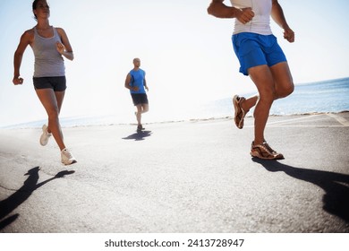 People, team and running at beach for cardio, fitness or outdoor workout together on asphalt or road. Athletic group or runners in sports, training exercise or street on sunny day by the ocean coast - Powered by Shutterstock