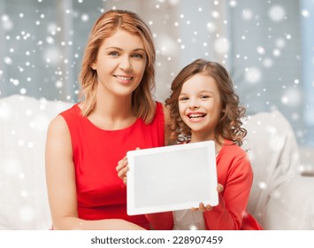 People, Technology, Christmas And Family Concept - Mother And Daughter Showing Tablet Pc Computer Blank Screen At Home