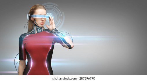 People, Technology, Future And Progress - Young Woman With Futuristic Glasses And Microchip Implant Or Sensors Over Gray Background With Virtual Projection And Laser Light