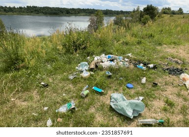 People throw garbage near lake in nature. Trash at camping resort. Garbage dump in Illegal location. Pile of rubbish in nature. Environmental pollution and ecology. Illegal dumping of Garbage.  - Shutterstock ID 2351857691