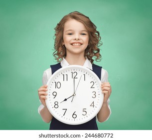 People, Time Management And Children Concept - Smiling Girl Holding Big Clock Showing 8 O'clock