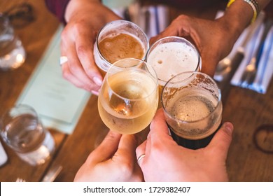 People toasting (cheers) with beer and wine at a bar or restaurant