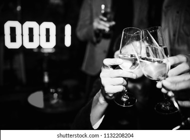 People Toasting With A Glass Of Champagne In A NYE Party