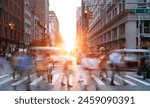 People and traffic in motion crossing the busy intersection of 5th Avenue and 23rd Street in New York City with sunlight background