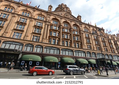 People And Traffic Pass The Famous Harrods Department Store On June 16, 2015 In London, UK. Opened In 1840 The Landmark Luxury Department Store Covers 80,000 Sqm Of Retail Space In Central London.