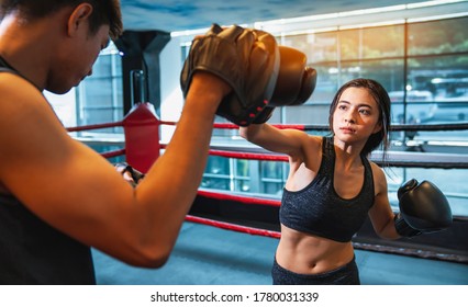 People Training During A Boxing Class In A Gym. Young Asian Woman Doing Kickboxing Training With Her Coach. Women On Boxing Training