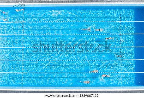 People
training in outdoor swimming pool, top
view
