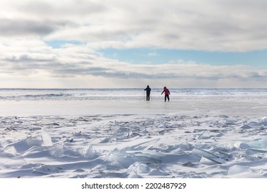 People Travel On Ice Skates On The Frozen Baikal Lake On A Cold Winter Day