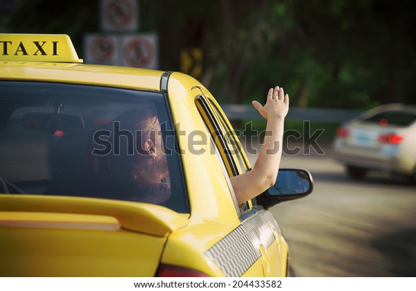 people travelling. Female\
passenger in taxi with arm outside of car window waving hand.\
Concept of freedom