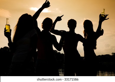 People (two Couples) On The Beach Dancing To Music, Drinking And Having A Lot Of Fun In The Sunset - Only Silhouette Of People To Be Seen