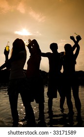 People (two Couples) On The Beach Dancing To Music, Drinking And Having A Lot Of Fun In The Sunset - Only Silhouette Of People To Be Seen