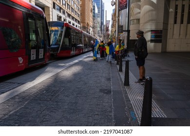 People With Ukrainian Flags At Protest In Central Business District While Moving Red Light Rail Passing By In Sydney Australia 30 August 2022.