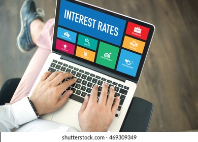 People using laptop in an office and INTEREST RATES concept on screen