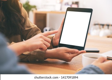 People Using And Looking At The Same Mockup Tablet Pc On Wooden Table Together