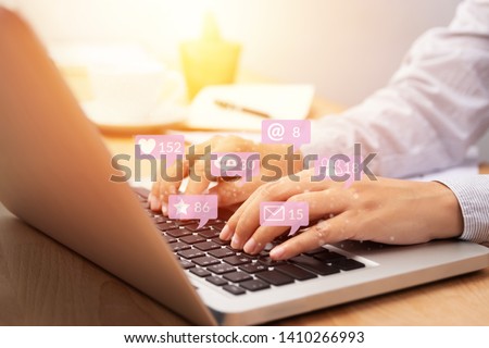 people using notebook computer laptop for social media interactions with notification icons from friend in social network with like, message, email, mention and star above smartphone screen. internet 
