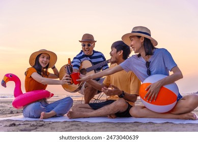 People vacation lifestyle journey concept. Happy asian diverse group friends having a picnic hang out and enjoy drinking liquor together on sea beach background outdoors during the sunset time. - Powered by Shutterstock