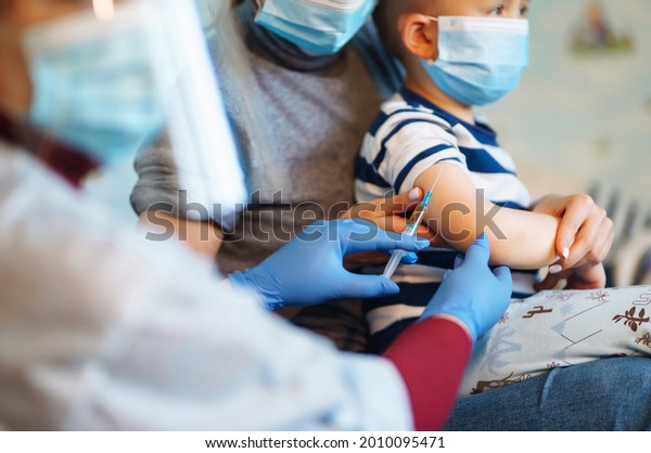 People vaccination concept for\
immunity health. Covid-19.  Children\'s doctor vaccinating little\
boy at home. Healthcare, coronavirus, prevention and\
immunize.