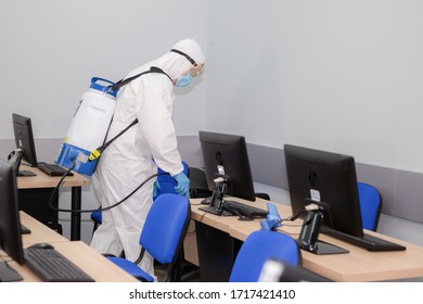 People in virus protective suits and mask disinfecting buildings of coronavirus with the sprayer, 