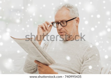 people, vision and mass media concept - senior man in glasses reading newspaper over snow
