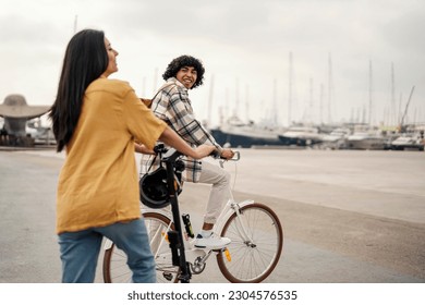 People are visiting Europe cities on the seaside. They are riding a bicycle and electric scooter and have fun. - Powered by Shutterstock