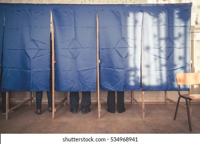 People Vote In A Voting Booth At A Polling Station.