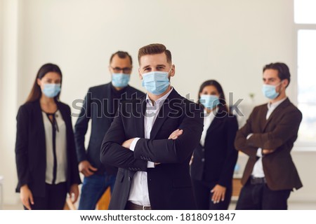 People vs covid. Young business company manager and team of responsible employees care about clients and coworkers wearing protective face masks in office due to the current epidemiological situation
