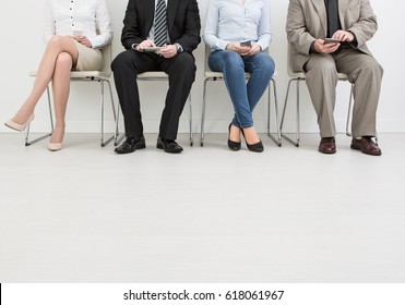 People are waiting for recruitment to hire an employer. They sit in a row. - Shutterstock ID 618061967