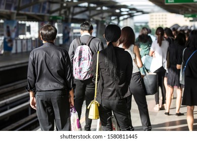 People waiting for a train at the platform during morning rush hour.