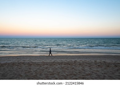 A people walk along the beach at Sunset pastel clear beautiful sky, beach and the blue sea in Huahin, Thailand