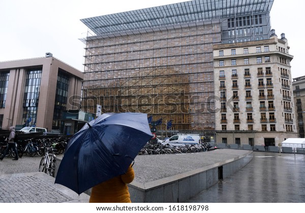 People walk during a\
heavy rainfall outside of European institutions in Brussels,\
Belgium on Dec. 13, 2019