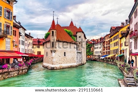People walk near the Thiou canal in Old Town of Annecy in France, encircling the medieval palace, Palais de l'Isle - Travel concept