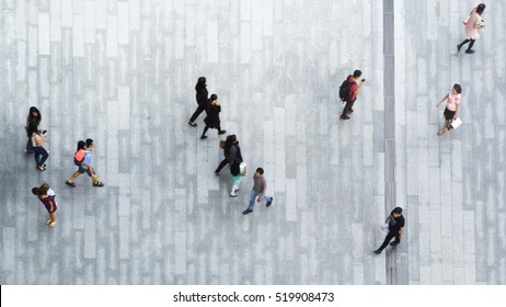 people walk on across the pedestrian concrete landscape in the city street (Aerial top view)