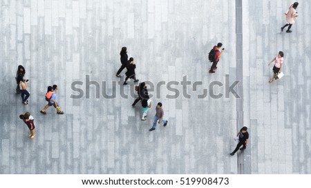 people walk on across the pedestrian concrete landscape in the city street (Aerial top view)