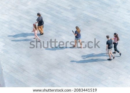 people walk on the pedestrian street walkway with the teenage young man and the group of family with little child. (Aerial urban city photo)