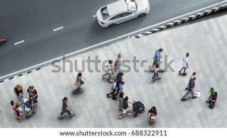 people walk on the pedestrian street walkway with the teenage young man and the group of family with little child with road and car transport. (Aerial urban city photo)