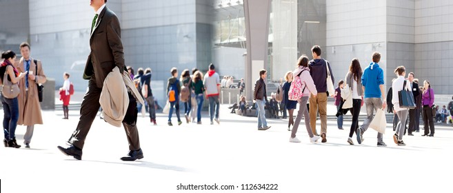 People walking against the light background of an urban landscape.