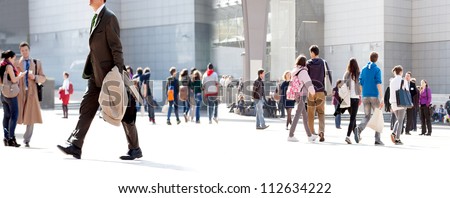 People walking against the light background of an urban landscape.