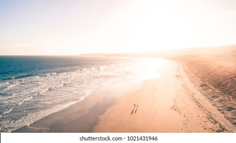 People Walking Along Beautiful Beach On The Great Ocean Road, Australia, At Sunset