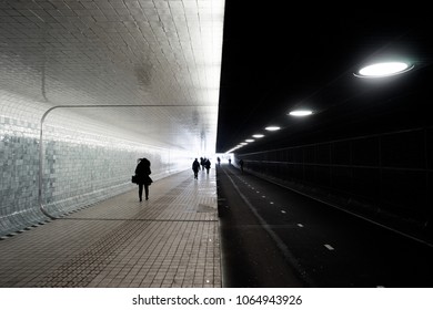 People walking and cycling through the beautiful Amsterdam Central Station tunnel; intentionally dramatic contrast - Powered by Shutterstock