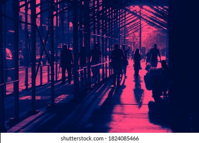 People Walking Down A Busy Sidewalk In New York City With Construction Scaffolding Overhead In Pink And Blue