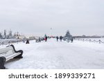 People walking down the pier with landed warcrafts and a lighthouse in Kronshtadt, Saint Petersburg, Russia.