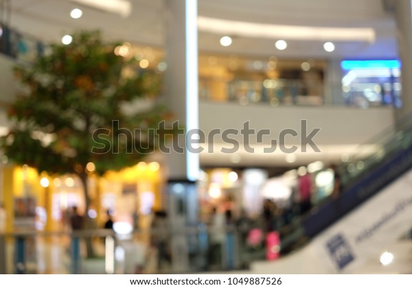 People walking up to escalator for\
shopping mall bright bokeh background and retail store blur\
background, Abstract Image blur. Blurred shopping\
background.
