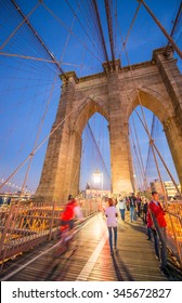 People Walking On Brooklyn Bridge At Night, New York City.