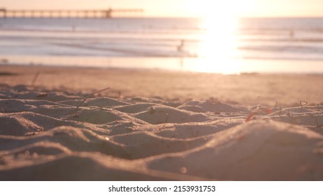 People walking on sandy Ocean Beach by pier at sunset, California coast, USA. Unrecognizable defocused family silhouettes in bright sun light, vacations on shorein sunshine. Sunlit sea water waves. - Powered by Shutterstock