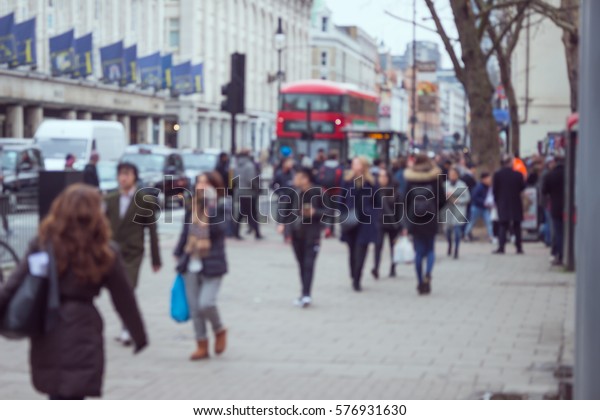 People\
walking on the side walk in a street in\
London.