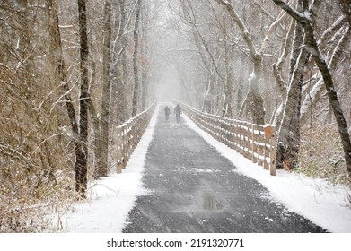 people walking on a trail during a brisk and snowy day. - Shutterstock ID 2191320771