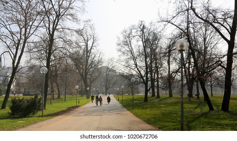 People Are Walking In The Park  In The Early Spring.