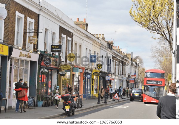People walking in the street with small shops\
and cafes at  Pembridge Road, Portobello, Notting Hill, London,\
Great Britain, UK. Space for copy.\
