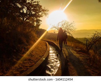 PEOPLE WALKING IN A SUNSET OVER MOUNTAINS - Shutterstock ID 1604112454